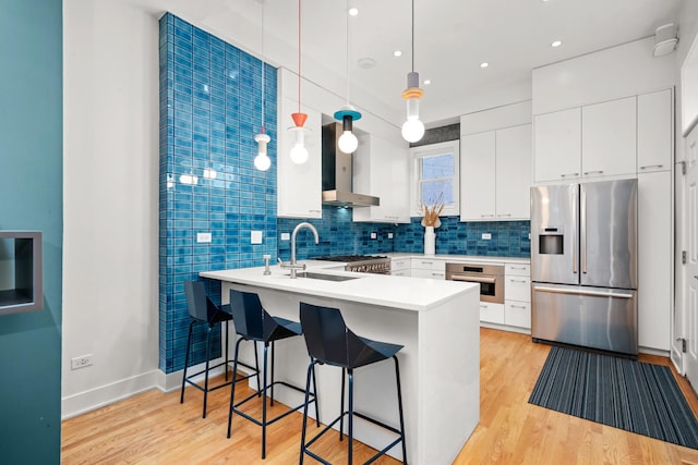 2113 N Clark St, Chicago, IL 60614 - kitchen featuring appliances with stainless steel finishes, wall chimney range hood, a sink, a peninsula, and light wood-style flooring