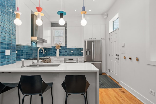 2113 N Clark St, Chicago, IL 60614 - kitchen featuring stainless steel fridge with ice dispenser, a peninsula, a kitchen bar, light wood-type flooring, and white cabinets