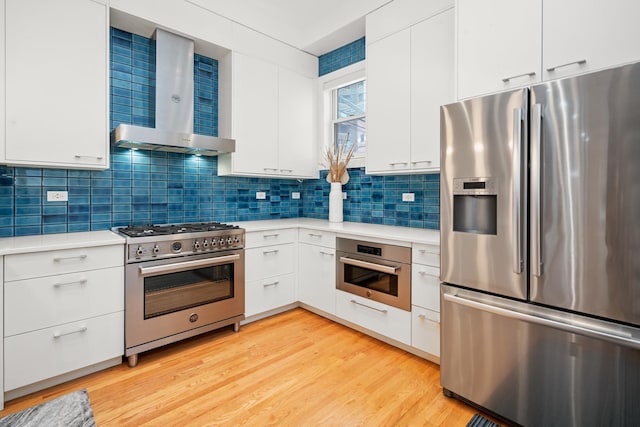 2113 N Clark St, Chicago, IL 60614 - kitchen with stainless steel appliances, wall chimney range hood, light countertops, and decorative backsplash