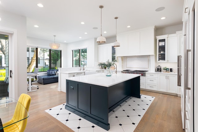 834 Wellner Rd, Naperville, IL 60540 - kitchen featuring light countertops, light wood-type flooring, white cabinets, recessed lighting, and decorative light fixtures