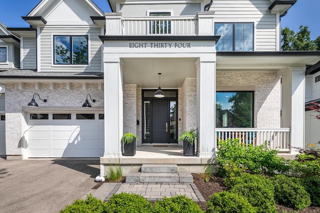 834 Wellner Rd, Naperville, IL 60540 - entrance to property with a garage, covered porch, asphalt driveway, and brick siding