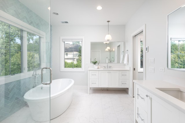 834 Wellner Rd, Naperville, IL 60540 - bathroom with healthy amount of natural light, two vanities, marble finish floors, a freestanding tub, and recessed lighting
