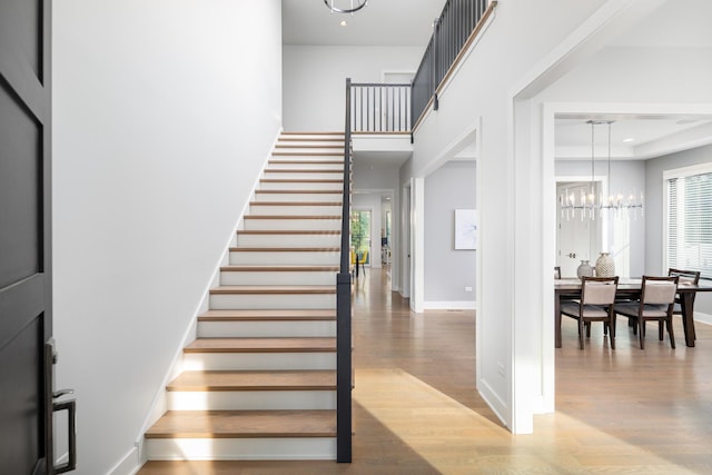 834 Wellner Rd, Naperville, IL 60540 - staircase with a chandelier, wood finished floors, and a towering ceiling