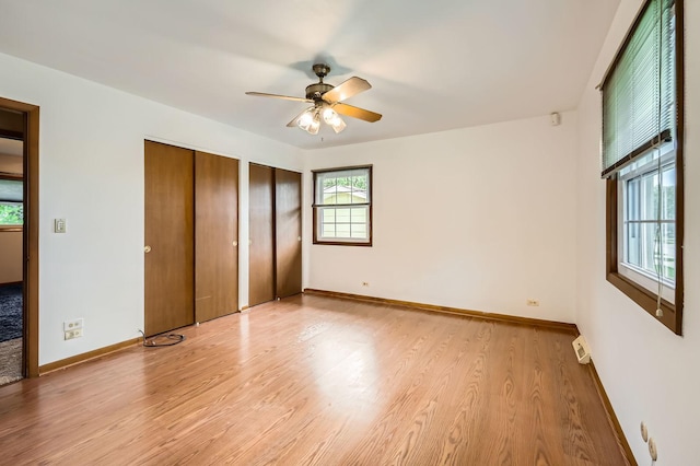 907 E Crabtree Dr, Arlington Heights, IL 60004 - unfurnished bedroom featuring multiple closets, light wood-style floors, and a ceiling fan