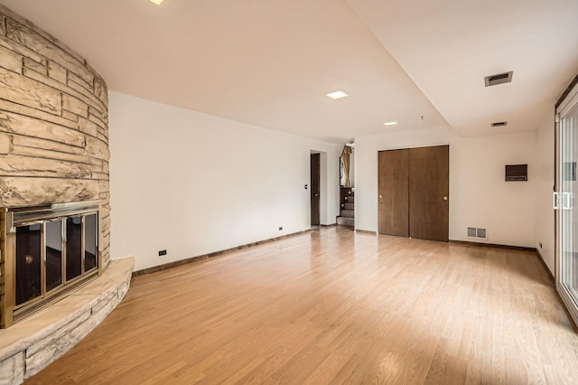 907 E Crabtree Dr, Arlington Heights, IL 60004 - unfurnished living room with light wood-style flooring, stairway, and a stone fireplace