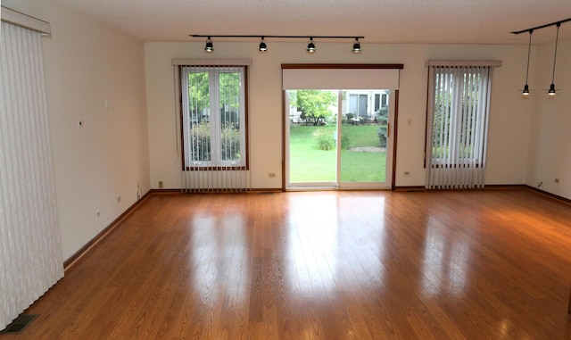 402 Catbird Ln, Deerfield, IL 60015 - empty room featuring track lighting, plenty of natural light, radiator, and wood finished floors