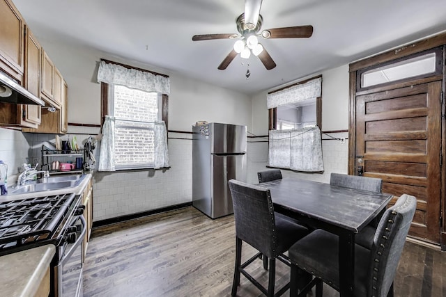 3425 W Lyndale St, Chicago, IL 60647 - dining area featuring a ceiling fan, wood finished floors, tile walls, and wainscoting