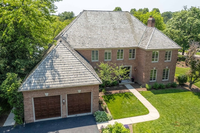 31 E Sandpiper Ln, Lake Forest, IL 60045 - view of front of property featuring a chimney, a front yard, brick siding, and a garage