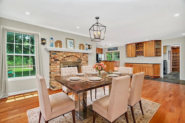 336 Brooklea Ct, Naperville, IL 60565 - dining room with a brick fireplace, dark wood finished floors, recessed lighting, a chandelier, and ornamental molding