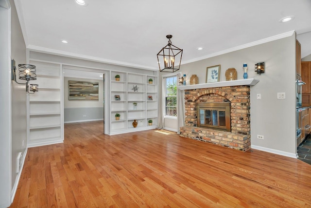 336 Brooklea Ct, Naperville, IL 60565 - unfurnished living room with ornamental molding, built in shelves, light wood-style flooring, a chandelier, and recessed lighting
