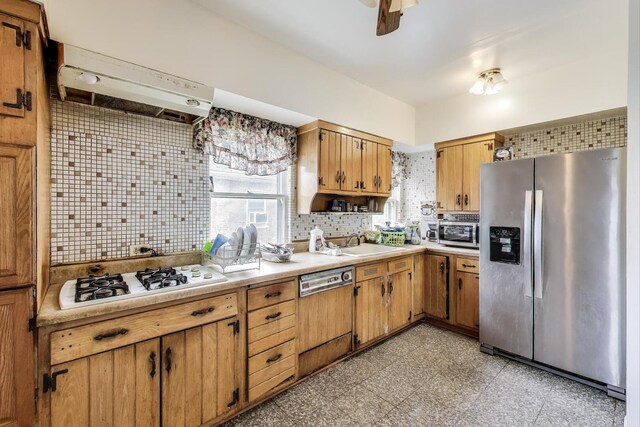 5042 W Wolfram St, Chicago, IL 60641 - kitchen featuring appliances with stainless steel finishes, range hood, decorative backsplash, and plenty of natural light