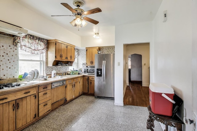 5042 W Wolfram St, Chicago, IL 60641 - kitchen with appliances with stainless steel finishes, backsplash, ceiling fan, light countertops, and brown cabinetry