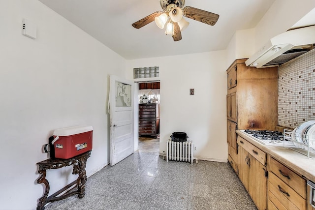 5042 W Wolfram St, Chicago, IL 60641 - kitchen featuring granite tiled floors, ceiling fan, tasteful backsplash, under cabinet range hood, and radiator heating unit