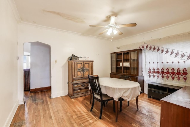 5042 W Wolfram St, Chicago, IL 60641 - dining area featuring ceiling fan, arched walkways, light wood-style flooring, and crown molding