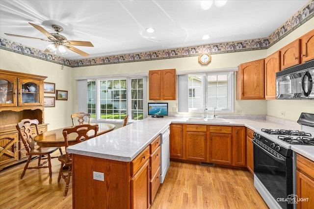 111 Fawn Ln, Elgin, IL 60120 - kitchen with range with gas stovetop, black microwave, light countertops, and healthy amount of natural light