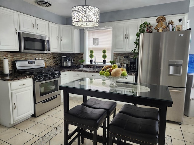 10806 S S Ave O, Chicago, IL 60617 - kitchen with stainless steel appliances, light tile patterned floors, white cabinetry, tasteful backsplash, and pendant lighting