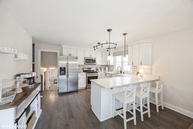 3925 Williams St, Downers Grove, IL 60515 - kitchen with appliances with stainless steel finishes, a peninsula, tasteful backsplash, and dark wood-style flooring