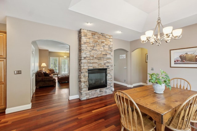 207 Quinlan Ave, Dekalb, IL 60115 - dining room with arched walkways, wood finished floors, a stone fireplace, a chandelier, and a raised ceiling