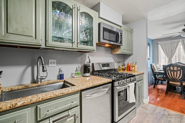 4000 Bayside Dr Unit 105, Palatine, IL 60074 - kitchen featuring green cabinets, stainless steel appliances, a ceiling fan, and light wood finished floors