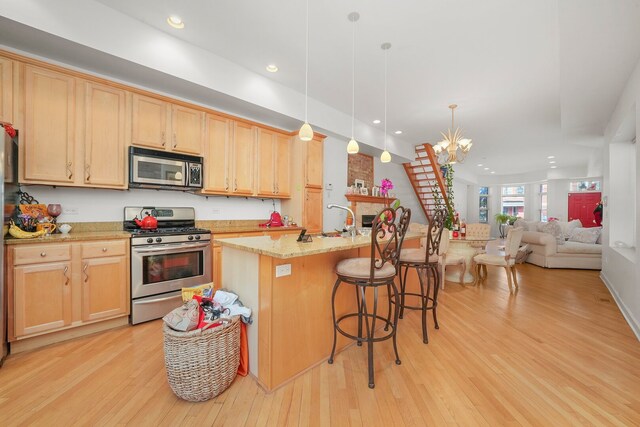 6505 S Woodlawn Ave, Chicago, IL 60637 - kitchen featuring appliances with stainless steel finishes, light wood-style floors, a chandelier, a sink, and light brown cabinets