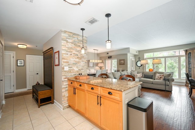 875 E 22nd St Unit 220, Lombard, IL 60148 - kitchen with open floor plan, light stone counters, hanging light fixtures, light tile patterned floors, and light brown cabinetry