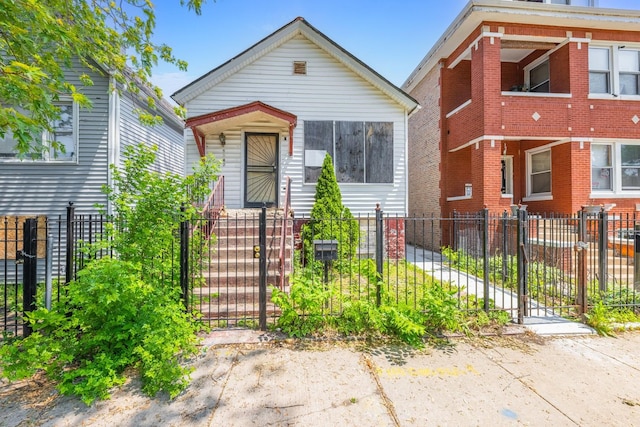 shotgun-style home featuring a fenced front yard and a gate