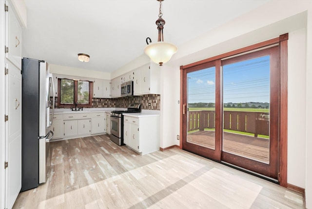 14023 S Split Rail Dr, Homer Glen, IL 60491 - kitchen with appliances with stainless steel finishes, light countertops, backsplash, light wood finished floors, and white cabinetry