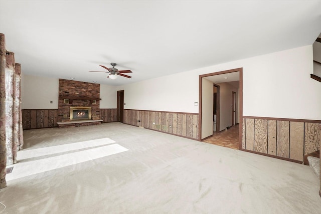 14023 S Split Rail Dr, Homer Glen, IL 60491 - unfurnished living room featuring a wainscoted wall, a ceiling fan, carpet flooring, a brick fireplace, and wood walls