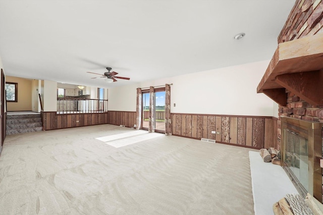 14023 S Split Rail Dr, Homer Glen, IL 60491 - unfurnished living room featuring a wainscoted wall, ceiling fan, carpet, a fireplace, and wood walls