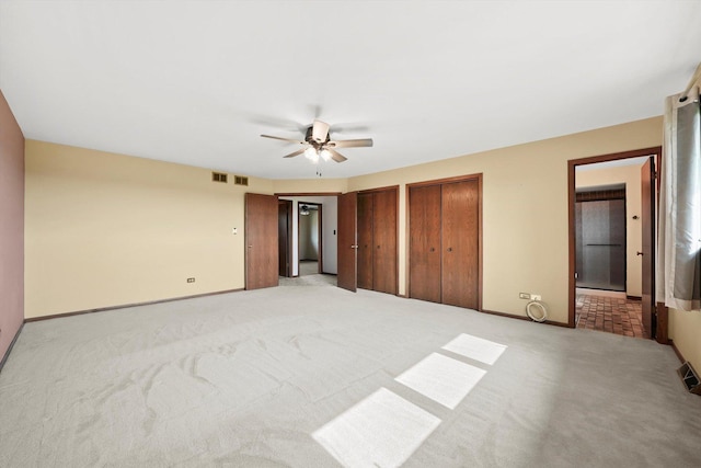 14023 S Split Rail Dr, Homer Glen, IL 60491 - unfurnished bedroom featuring light colored carpet, multiple closets, ceiling fan, and ensuite bath