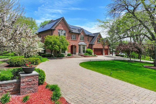 1400 Banbury Rd, Inverness, IL 60067 - tudor home featuring curved driveway, solar panels, a front yard, and brick siding