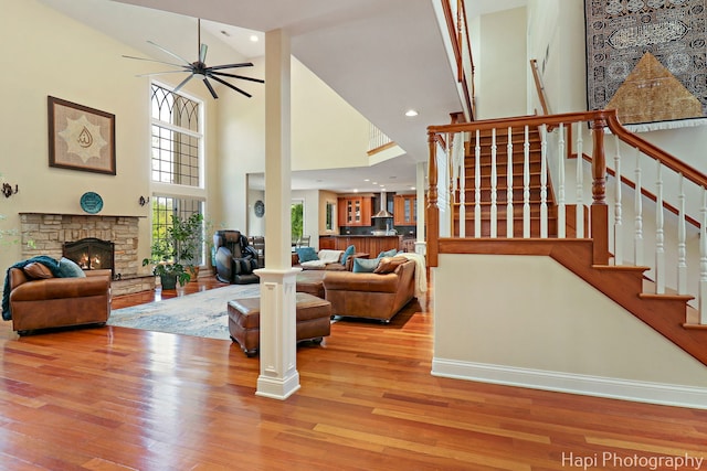 1400 Banbury Rd, Inverness, IL 60067 - living room with wood finished floors, a towering ceiling, a fireplace, ceiling fan, and stairs