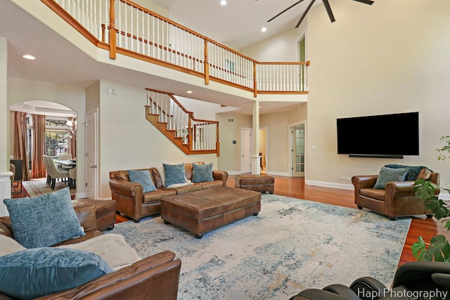 1400 Banbury Rd, Inverness, IL 60067 - living room featuring a towering ceiling, ceiling fan, stairway, arched walkways, and wood finished floors