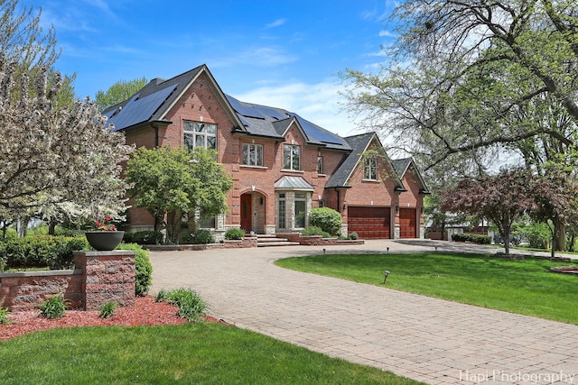 1400 Banbury Rd, Inverness, IL 60067 - english style home with curved driveway, brick siding, a front yard, roof mounted solar panels, and a garage