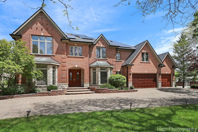 1400 Banbury Rd, Inverness, IL 60067 - view of front of house featuring brick siding, decorative driveway, solar panels, stone siding, and a garage