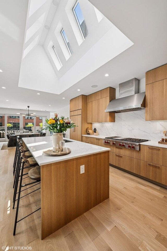 226 S Green St Unit 4N, Chicago, IL 60607 - kitchen with wall chimney exhaust hood, modern cabinets, stainless steel gas stovetop, high vaulted ceiling, and recessed lighting