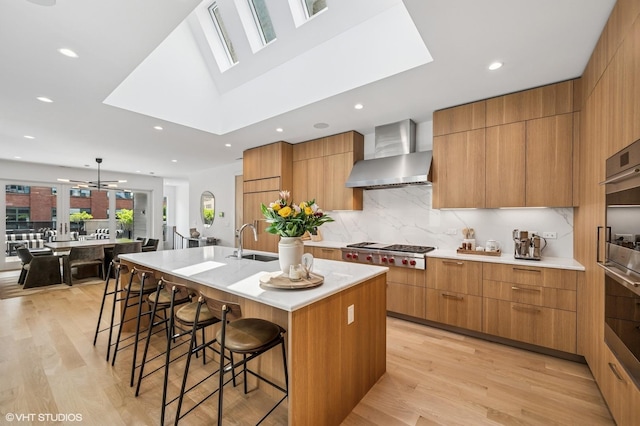 226 S Green St Unit 4N, Chicago, IL 60607 - kitchen with wall chimney range hood, modern cabinets, appliances with stainless steel finishes, a breakfast bar, and recessed lighting