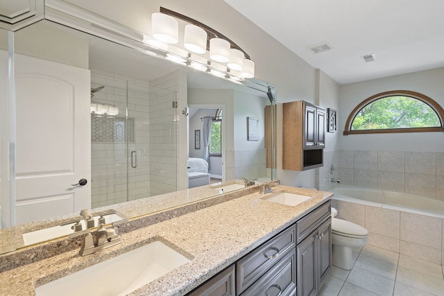 ensuite bathroom featuring double vanity, a garden tub, a stall shower, and tile patterned floors