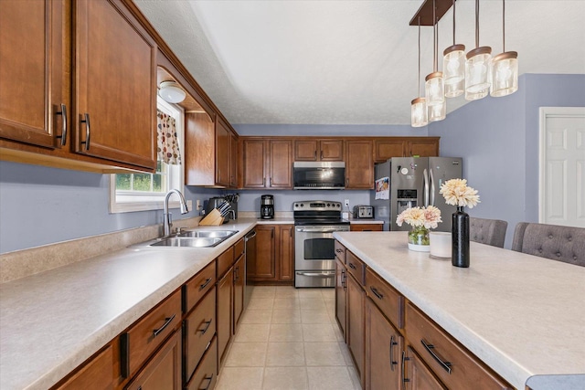 3905 Boulder Ridge Dr, Champaign, IL 61822 - kitchen with stainless steel appliances, brown cabinets, pendant lighting, light countertops, and light tile patterned floors