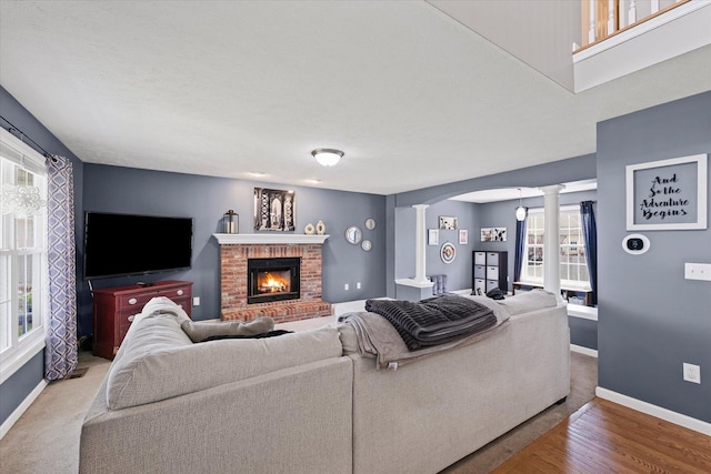3905 Boulder Ridge Dr, Champaign, IL 61822 - living area featuring ornate columns, arched walkways, a brick fireplace, and wood finished floors