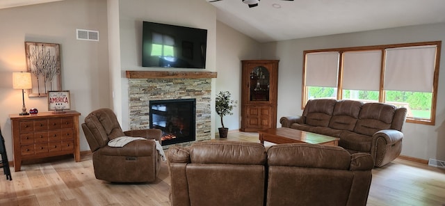 6638 Key Largo Dr, Machesney Park, IL 61103 - living room featuring vaulted ceiling, a ceiling fan, light wood-type flooring, a stone fireplace, and baseboards