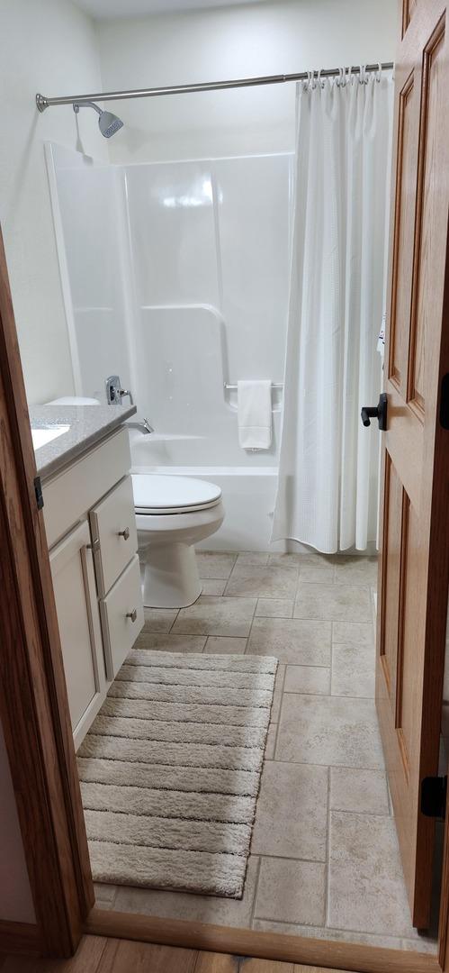 6638 Key Largo Dr, Machesney Park, IL 61103 - bathroom featuring shower / tub combo with curtain, vanity, and stone finish flooring