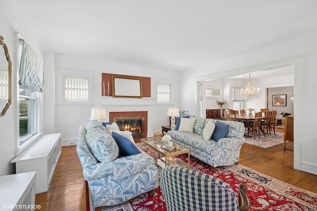 1241 Forest Ave, Wilmette, IL 60091 - living area featuring a glass covered fireplace, wood finished floors, and a chandelier