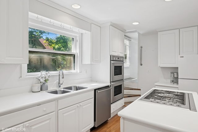 1241 Forest Ave, Wilmette, IL 60091 - kitchen featuring stainless steel appliances, white cabinets, light wood finished floors, recessed lighting, and light countertops