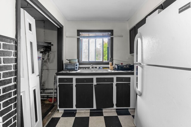 14217 Turner Ave, Robbins, IL 60472 - kitchen with freestanding refrigerator, a sink, light flooring, dark countertops, and dark cabinets