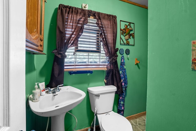 14217 Turner Ave, Robbins, IL 60472 - bathroom featuring toilet, baseboards, and a sink