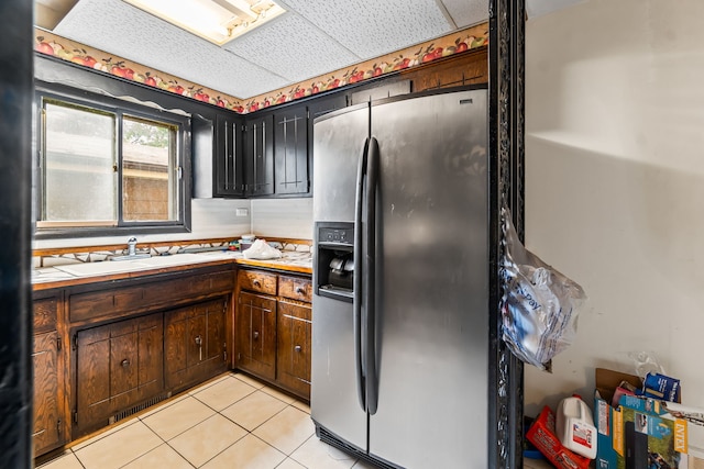 14217 Turner Ave, Robbins, IL 60472 - kitchen featuring stainless steel fridge, a sink, light countertops, light tile patterned floors, and dark brown cabinets