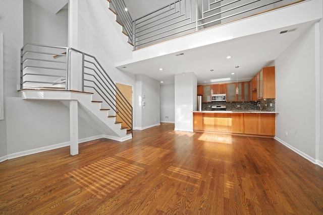1550 N Leavitt St Unit 1550, Chicago, IL 60622 - unfurnished living room featuring stairs, dark wood finished floors, and a towering ceiling