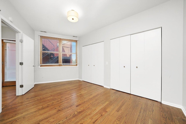 1550 N Leavitt St Unit 1550, Chicago, IL 60622 - unfurnished bedroom with two closets and wood finished floors