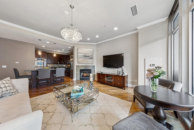 333 N Canal St Unit 2505, Chicago, IL 60606 - living room featuring ornamental molding, recessed lighting, light wood-type flooring, a chandelier, and a tiled fireplace